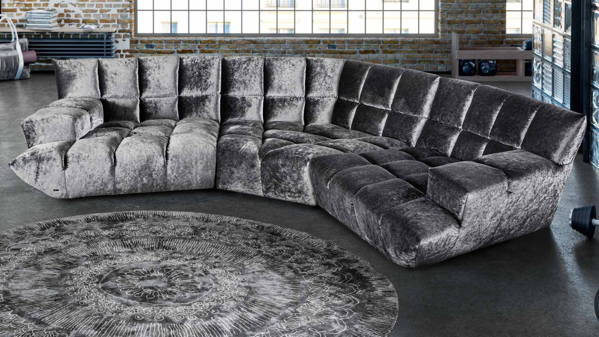 bretz cloud 7 sofa in grau vor einem runden grauen teppich